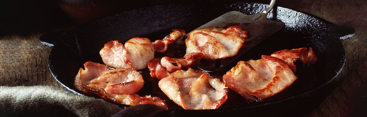Tocineta siendo cocinada en una sartén. Tocineta siendo cocinada en una sartén.