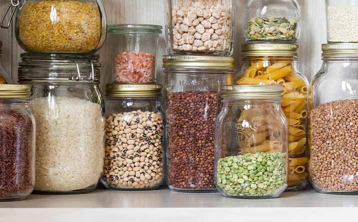 Alacena con frascos llenos de legumbre y cereales Alacena con frascos llenos de legumbre y cereales