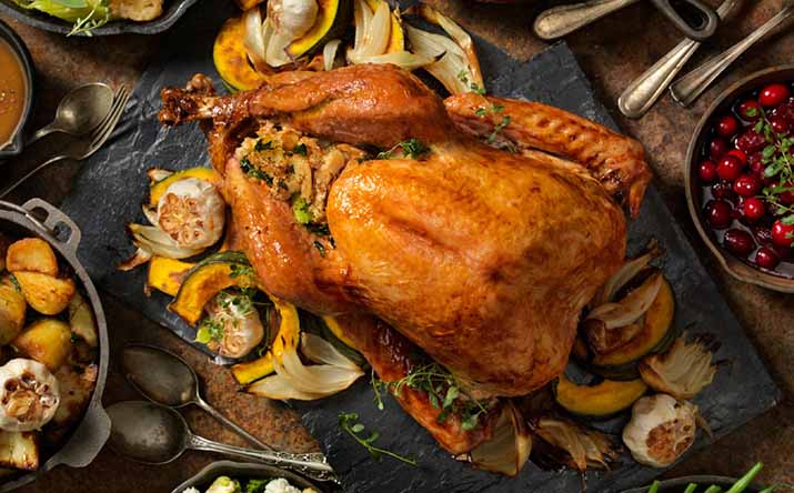 Un jamón de pavo acompañado de diferentes guarniciones navideñas. Un jamón de pavo acompañado de diferentes guarniciones navideñas.