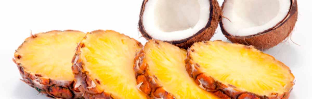 Tajadas de piña y un coco partido por la mitad, dos frutas tropicales Tajadas de piña y un coco partido por la mitad, dos frutas tropicales