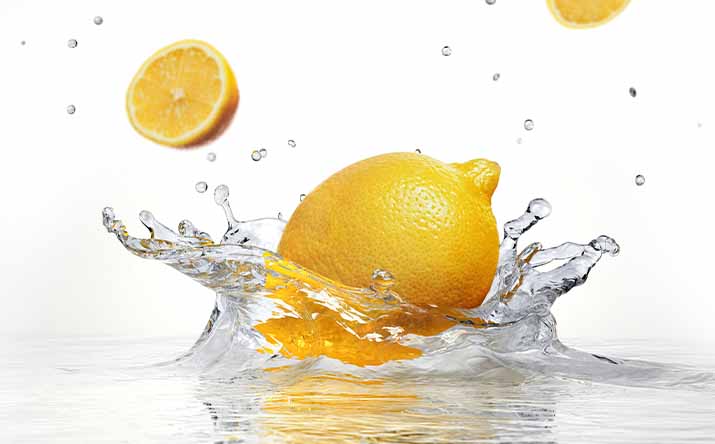 Un tipo de limón amarillo cayendo en el agua Un tipo de limón amarillo cayendo en el agua