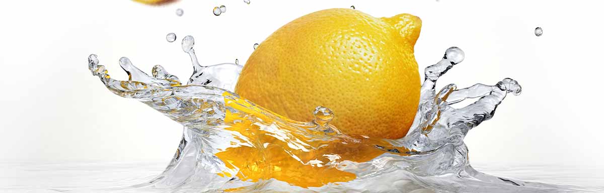 Un tipo de limón amarillo cayendo en el agua Un tipo de limón amarillo cayendo en el agua