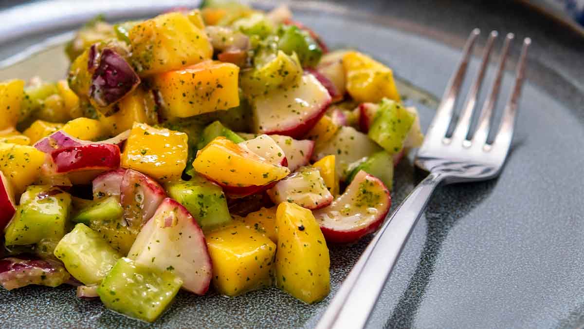 Una ensalada con mango y verduras, con su aderezo. Una ensalada con mango y verduras, con su aderezo.