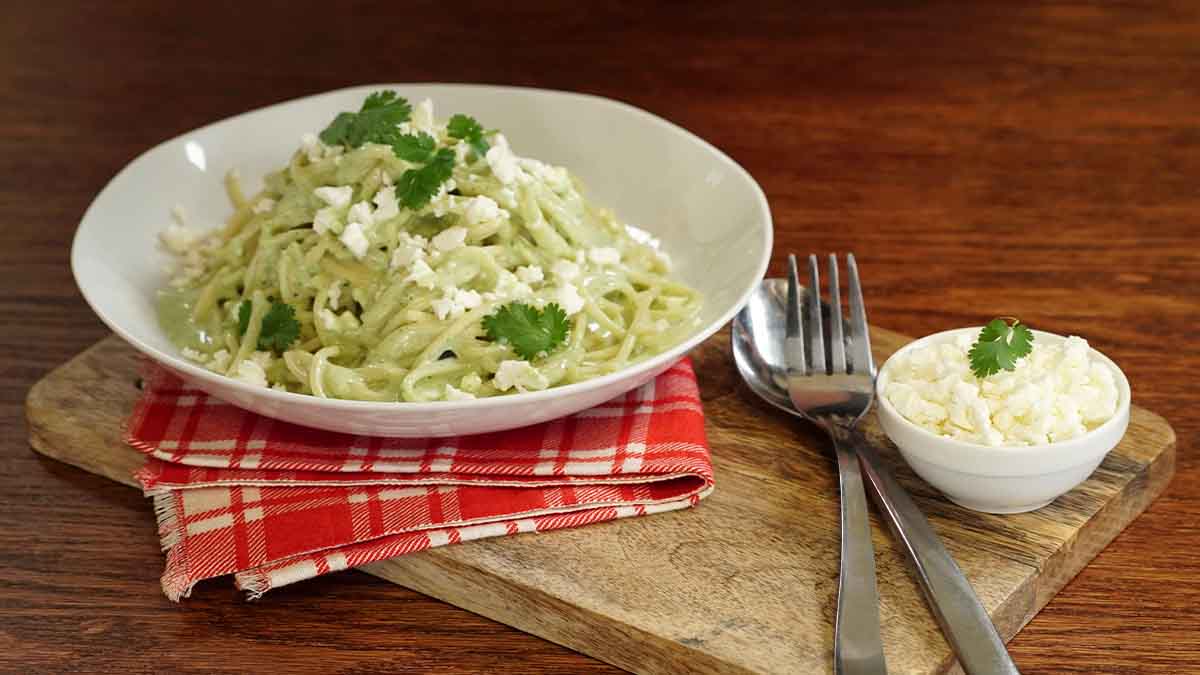 Pasta aromatizada con cilantro, servida en un plato blanco. Pasta aromatizada con cilantro, servida en un plato blanco.