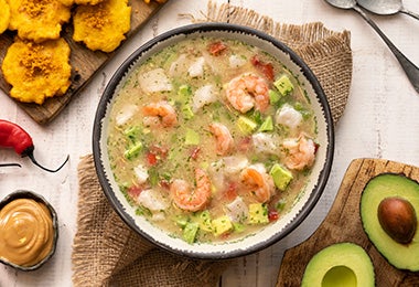 Plato de caldo de pescado con camarones, chiles, plátano y aguacate Plato de caldo de pescado con camarones, chiles, plátano y aguacate