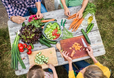 Los tipos de corte se usan con frecuencia en verduras para darle variedad visual a los platos. Familia partiendo verduras con diferentes tipos de corte para preparar una ensalada.