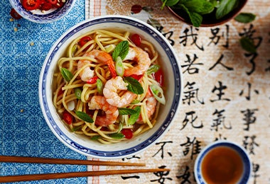 La combinación de fideos y alimentos de mar es un clásico en la comida típica de China Plato con fideos y camarones, comida típica de China.