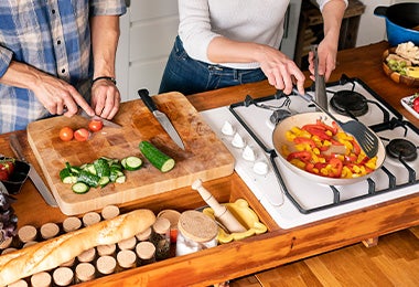 Pareja cocinando pan y vegetales contaminación cruzada Pareja cocinando pan y vegetales contaminación cruzada