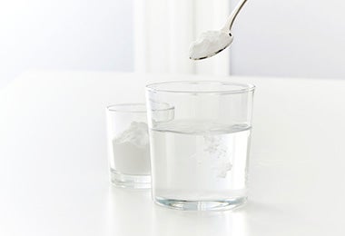 Vaso y cuchara para disolver bicarbonato de sodio para cocinar Vaso y cuchara para disolver bicarbonato de sodio para cocinar