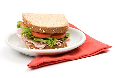 Cómo preparar un sándwich relleno jamón, tomate y lechuga Cómo preparar un sándwich relleno jamón, tomate y lechuga plato y servilleta