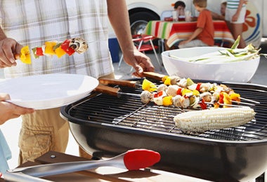 El kebab turco es muy bueno para un asado en familia. Familia preparando kebab turco.