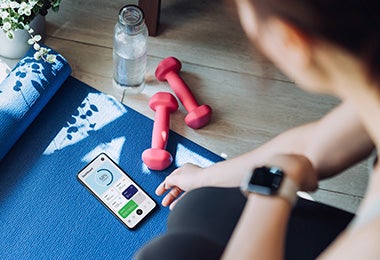 Recuperación post entrenamiento qué comer después de hacer ejercicio Mujer con mancuernas y mat de entrenamiento qué comer después de hacer ejercicio