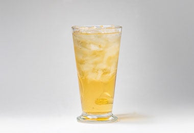 Vaso de kombucha clara con hielo, bebida dorada lista para consumir.
