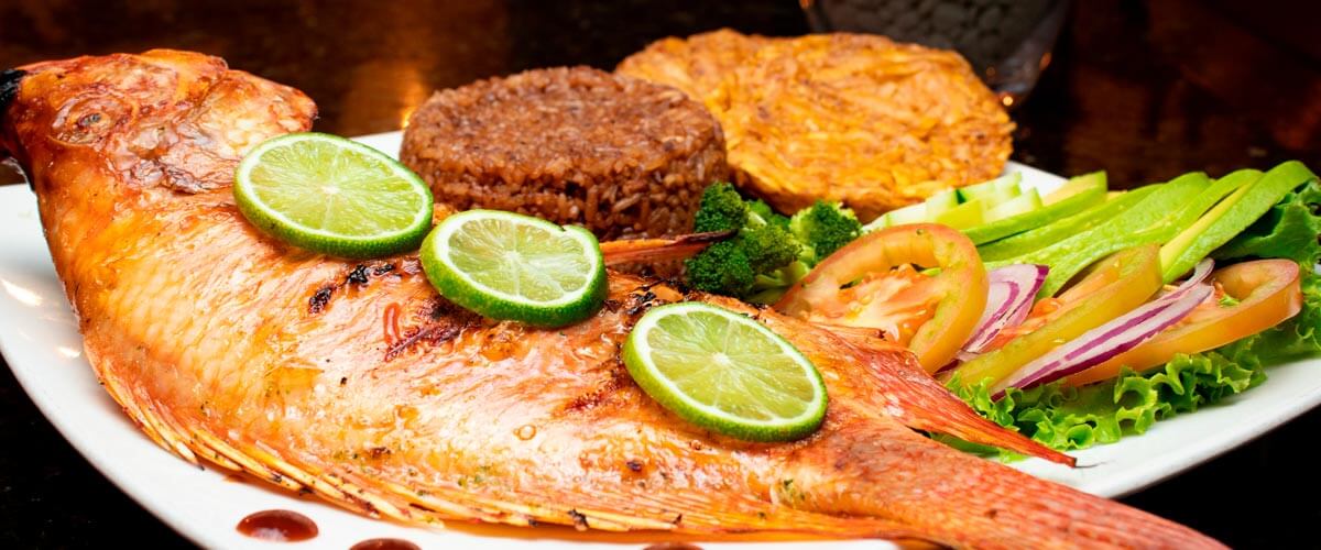 Mojarra con ensalada de aguacate, arroz con coco, plátano y limón