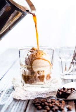Café negro vertido sobre bola de helado para forma un afogato con tapioca.