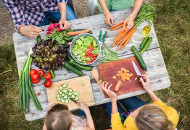 Una familia preparando una ensalada