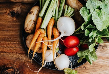  Verduras, como zanahorias, papas y nabos, sobre un plato, para cocinar al vapor.