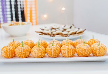Mandarinas decoradas como calabazas para una fiesta de Halloween
