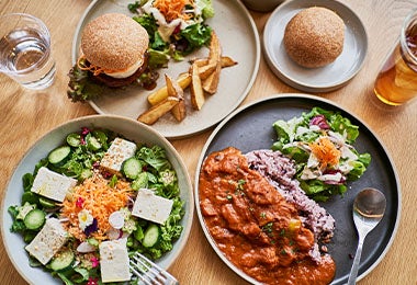 Comidas veganas, como tofu con ensalada y soya texturizada, en una mesa. 