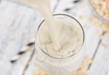 Leche de avena en un vaso, una alternativa vegana para remplazar la leche de origen animal.