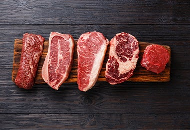 Tabla de picar con distintos tipos de cortes de carne para su cocción.