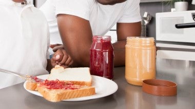 Untar mermelada casera de fresa y mantequilla de maní en una rebanada de pan