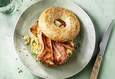 Desayuno con pan bagel de tocino y huevo