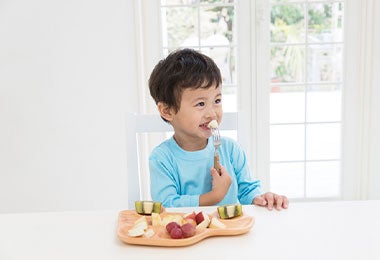 Pequeño niño degustando una receta de frutas.