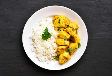 Un pollo estofado al curry, acompañado de arroz