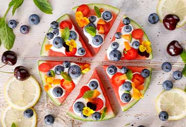 Una pizza frutal decorada con flores comestibles. 