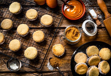 Galletas rellenas de chocolate y arequipe sobre la base de un horno.