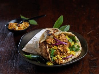 Gyro de pollo envuelto en pan pita con arroz y vegetales frescos