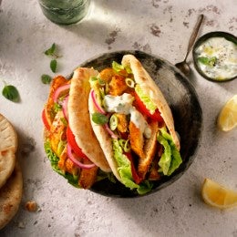 Gyro de pollo estilo griego con lechuga, tomate, cebolla y salsa tzatziki