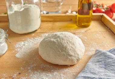 Masa de empanadillas de arroz sobre mesón de madera.