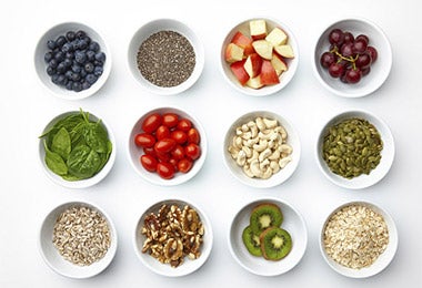 Diferentes ingredientes después de realizar el mise en place para cocinar, como maní, frutas, cereales y hierbas