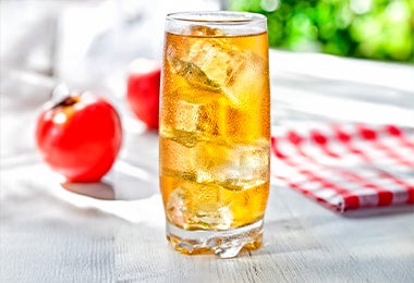 Refrescante jugo de manzana con hielo para tomar junto a un aperitivo de queso provolone