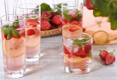 Vasos de bebida limonada de fresa para fiesta de colores.