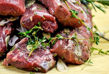 Carne marinada y sazonada sobre tabla de picar previo a su ahumado.
