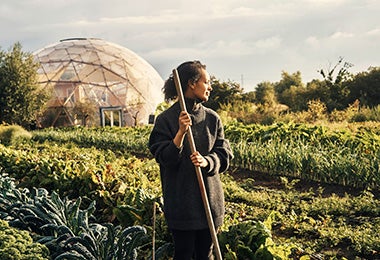 Una mujer disfrutando de la conexión con la naturaleza mientras cultiva su comida