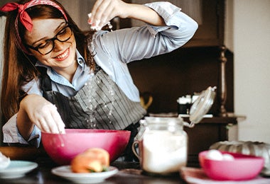 Mujer preparando arepas rellenas con harina de maíz en bowl 