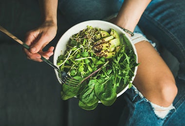  Una mujer utilizando verduras verdes en su plan de alimentación