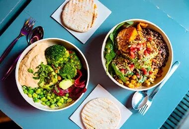 Mesa con dos platos de comida con vegetales