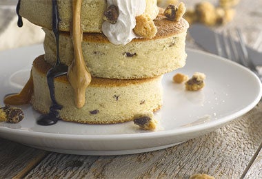 Pancakes esponjosos con crema y salsas dulces, un desayuno perfecto para disfrutar durante películas de Navidad.