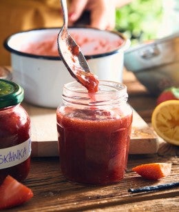 Llenando recipiente de vidrio con mermelada casera de fresa