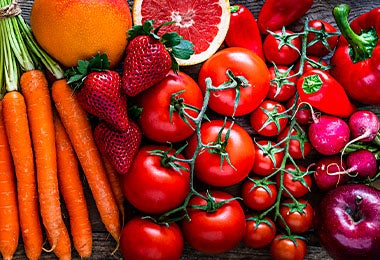 Tomates junto a otras frutas y verduras, como zanahorias y fresas.
