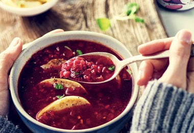 Persona consumiendo sopa caliente con bulgur y remolacha