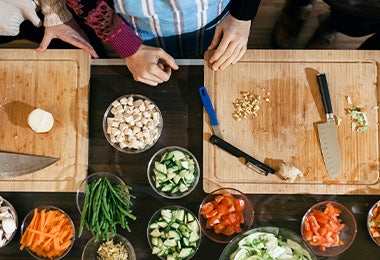 Tabla de corte con cuchillos y verduras cortadas   