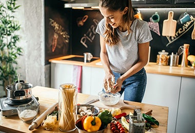 Una mujer preparando una pizza casera. 