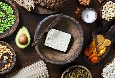 Tofu sólido en una mesa, acompañado de otros alimentos.