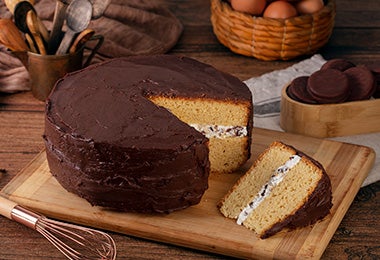 Mesa con torta de cumpleaños de vainilla con cobertura de chocolate